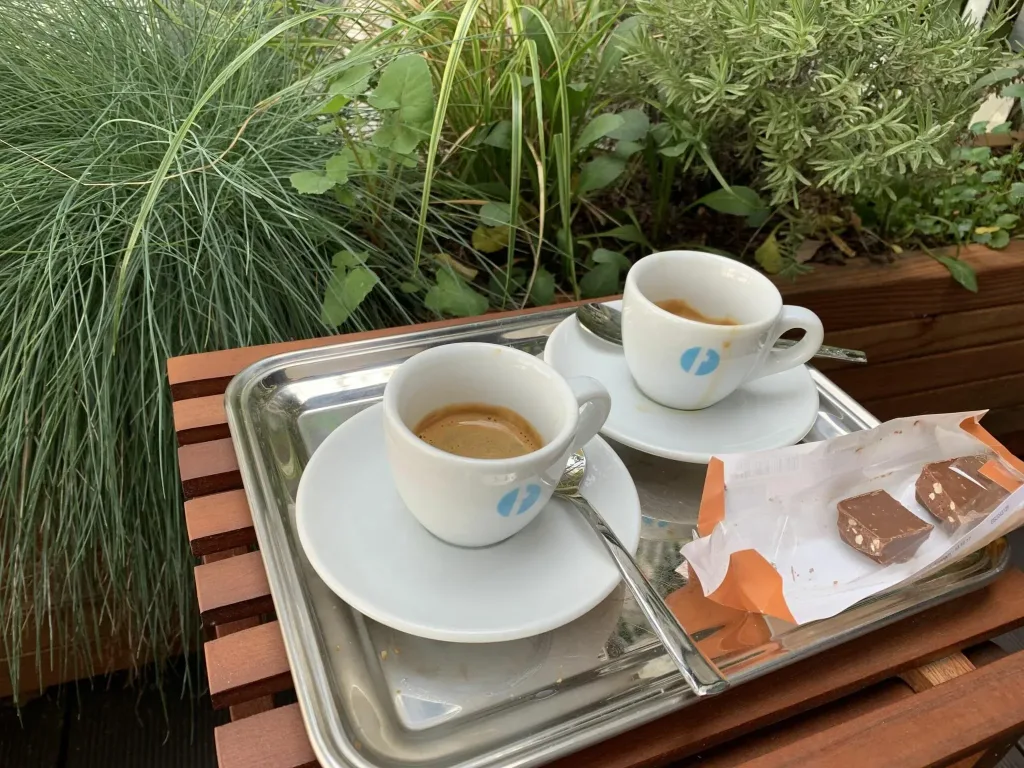 Italienischer Espresso auf einem Tisch am begrünten Balkon werden von der Persönlichen Assistenz in den bezahlten Pausen genossen.