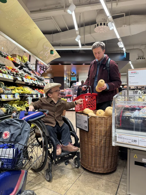 Einkaufen eines Kürbis mit der Unterstützung von Persönlicher Assistenz in einem Supermarkt